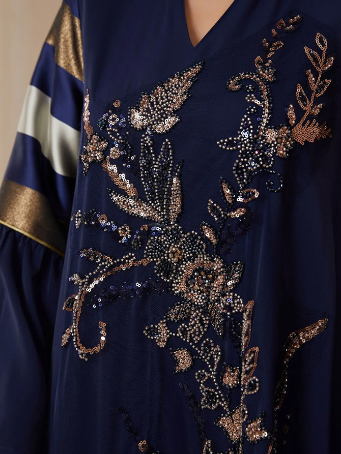 Imperia Luxe Embellished Navy Blue Maxi Dress featuring intricate floral embellishments, striped sleeve and back panels, flowing bell sleeves, and a graceful full-length silhouette for women - TORFEO
